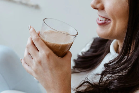 A woman enjoying a glass of creamy shake